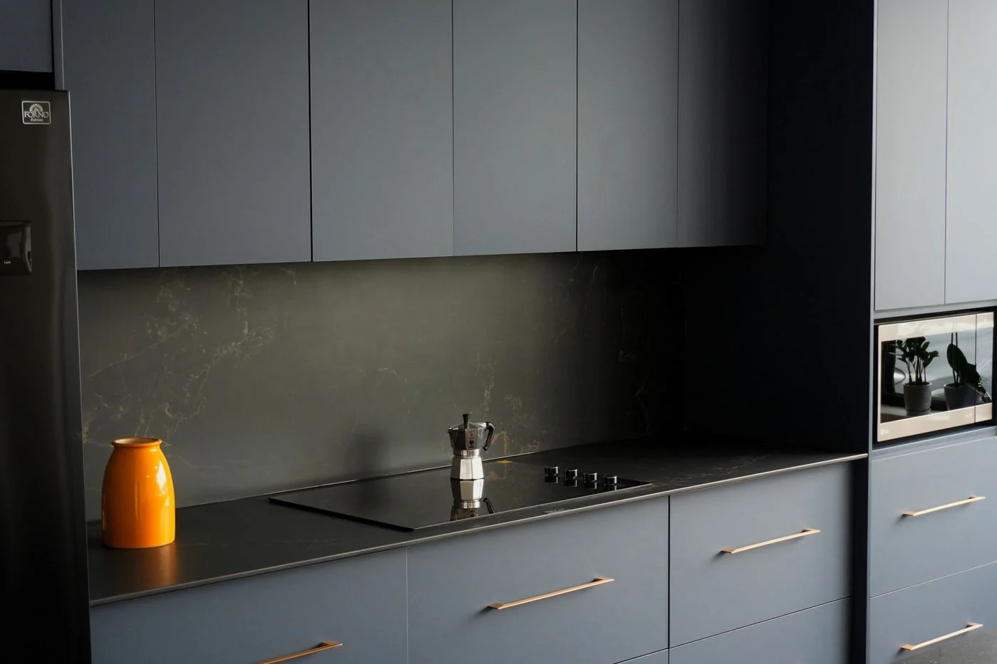 Graphite matte flat panel kitchen doors with slim brass bar pulls and a dark quartz backsplash, Montreal