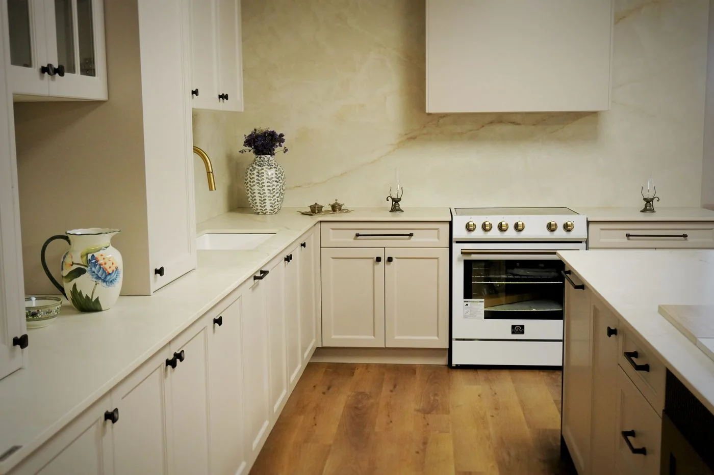 Cream classic kitchen with a plaster hood, a white range and a warm hardwood floor, Montreal