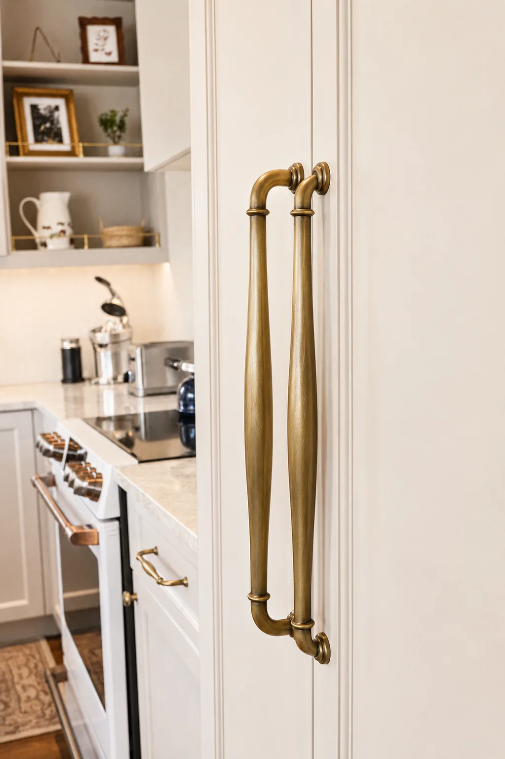 Brushed brass appliance pulls on cream panelled pantry doors in a custom Terrebonne kitchen
