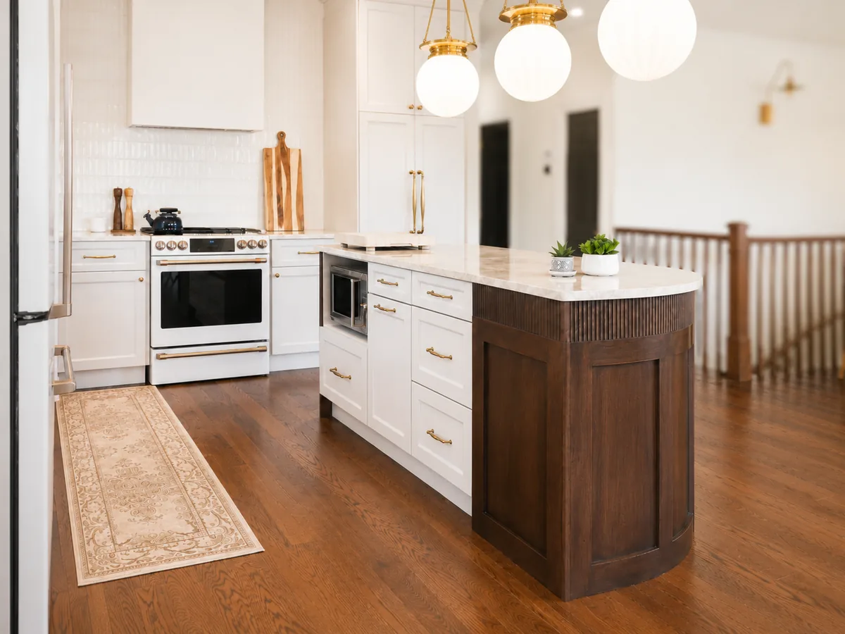 Cream shaker kitchen with white Café range, brass hardware and curved maple island in Terrebonne