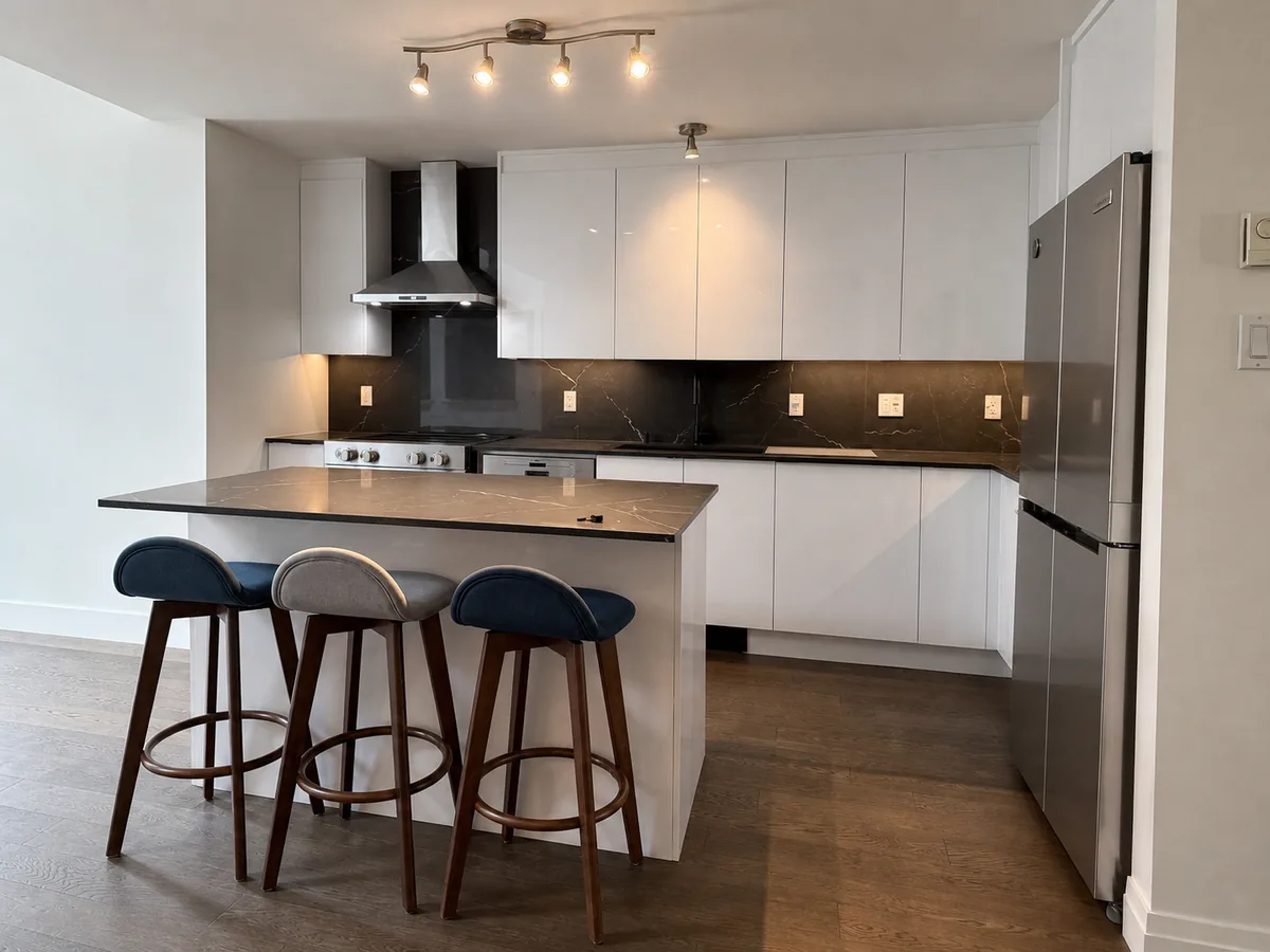 Cuisine blanche sans poignées avec îlot de sept pieds et trois tabourets en soirée, Pierrefonds