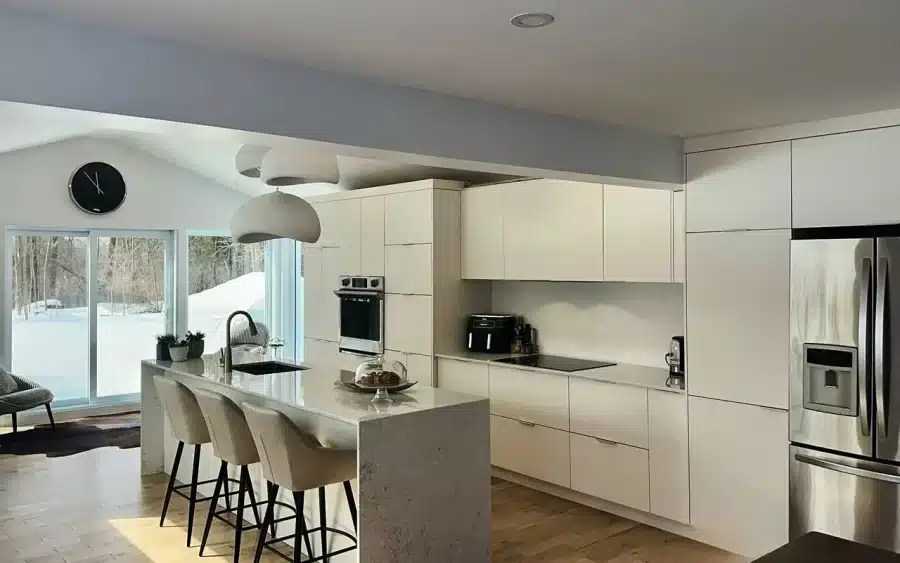 Matte white custom kitchen with a double waterfall quartz island, built by Limakdéco in Laval
