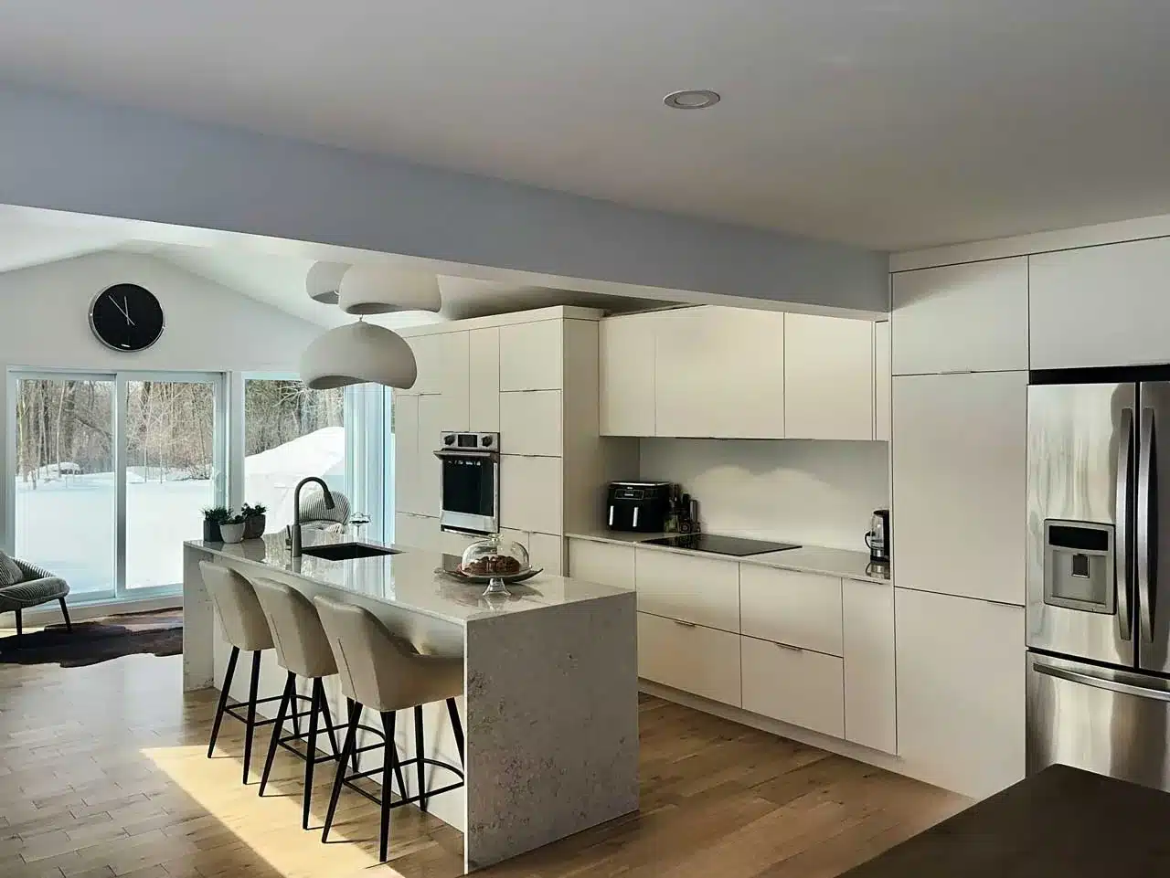 Matte white custom kitchen with a double waterfall quartz island, built by Limakdéco in Laval