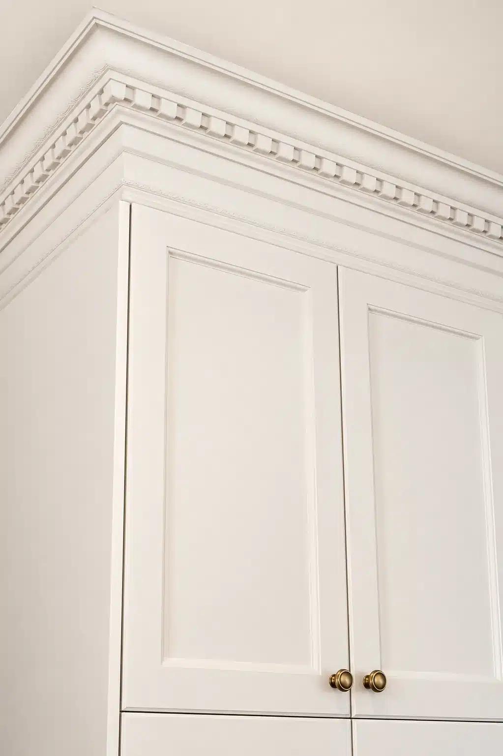 Dentil crown moulding above the cream cabinets in the Terrebonne kitchen