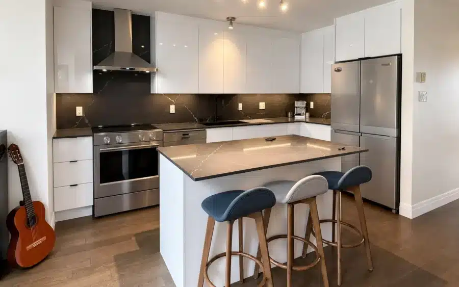 Handleless white kitchen with black quartz island completed by Limakdéco in Pierrefonds in February 2026