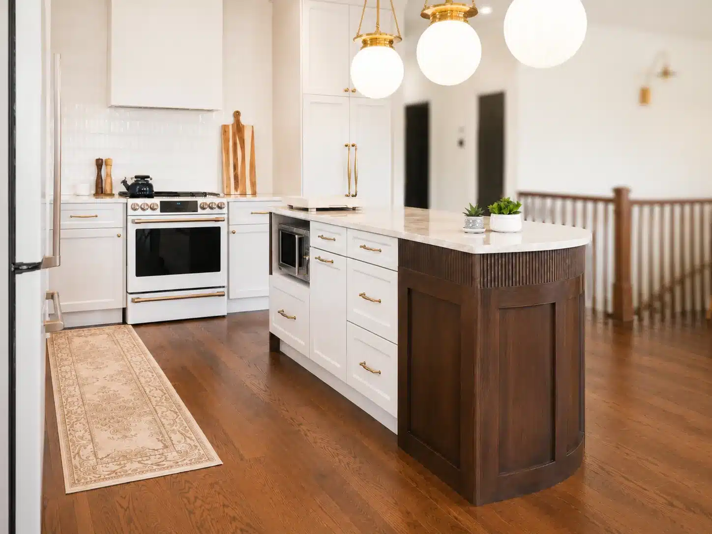Taj Mahal quartzite counters, cream cabinets and a ceramic tile backsplash in Limakdéco’s Terrebonne kitchen